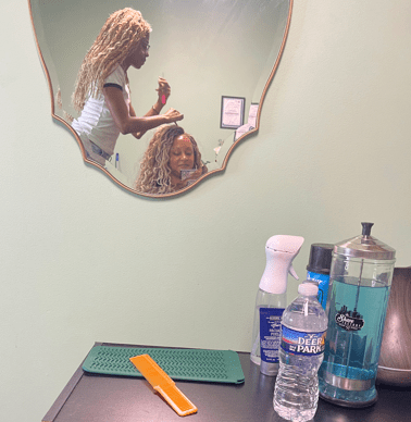 Cache Wright standing on a stool to complete Chrystal's hairstyle